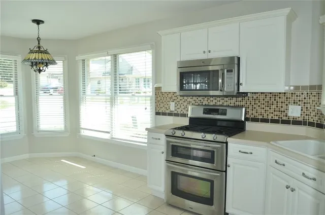 a kitchen with granite countertop white cabinets and white appliances