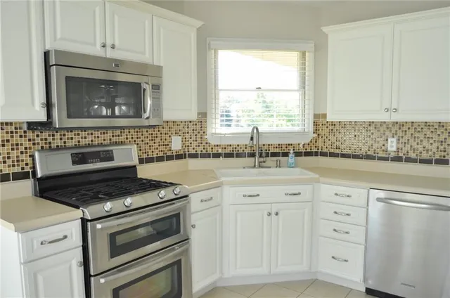 a kitchen with cabinets and stainless steel appliances