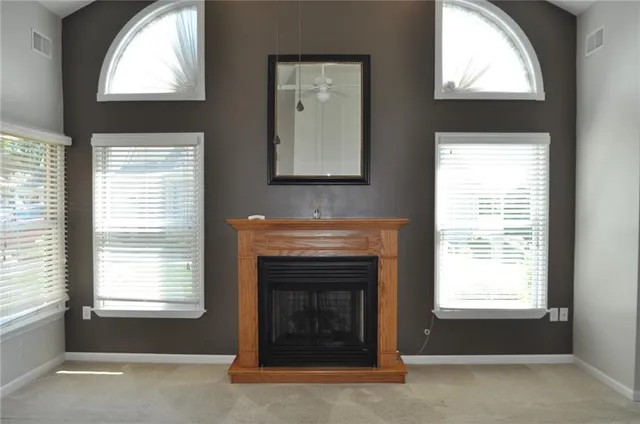 a living room with a fireplace and windows