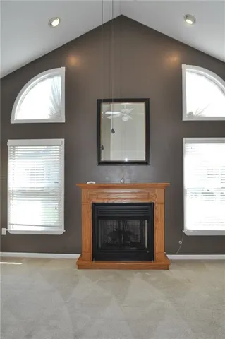 a view of an empty room with a window and fireplace