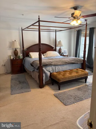 a bedroom with a bed a chandelier and dresser