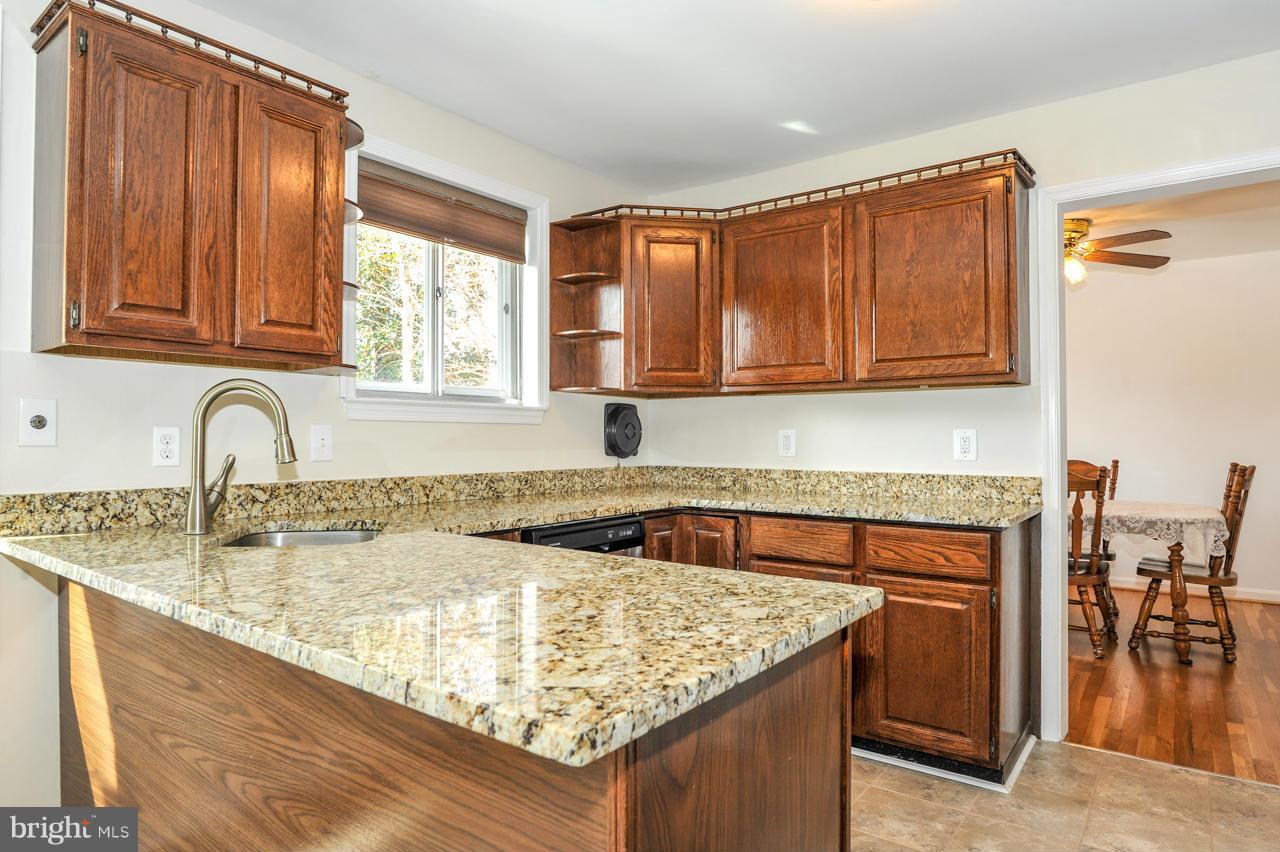 6910 Vancouver Road Springfield, VA 22152 - Photo 7 of 28 a kitchen with granite countertop a sink dishwasher stove and cabinets with wooden floor