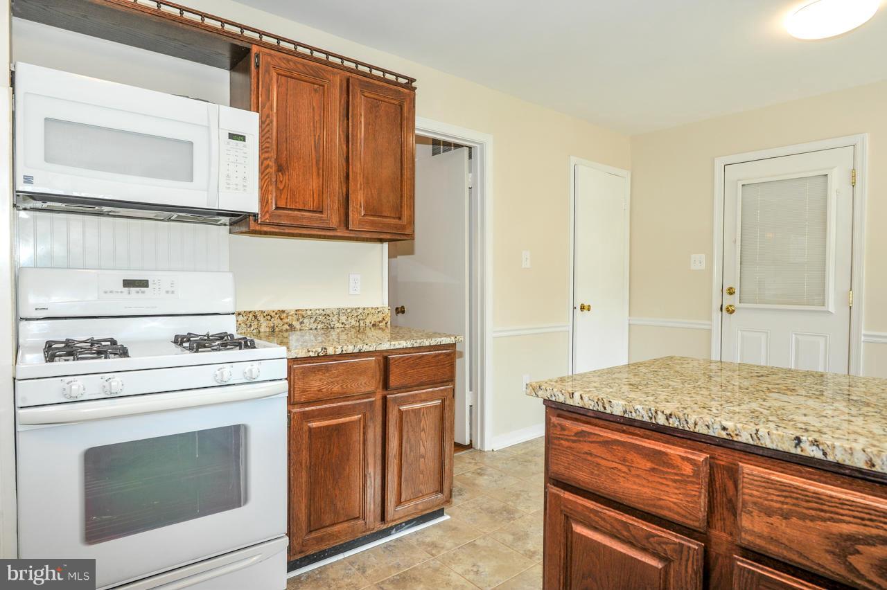 6910 Vancouver Road Springfield, VA 22152 - Photo 9 of 28 a kitchen with stainless steel appliances granite countertop a stove and a refrigerator