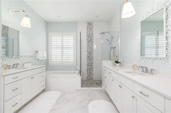 a spacious bathroom with a double vanity sink mirror double shower and a bathtub