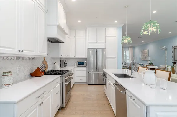 a kitchen with a sink a refrigerator and cabinets