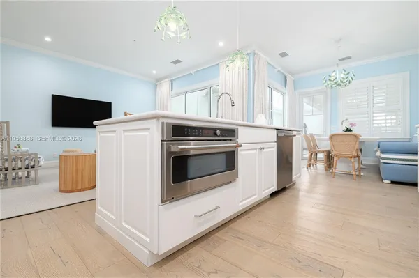 a kitchen with stainless steel appliances a white stove top oven a sink dishwasher and a refrigerator with wooden floor