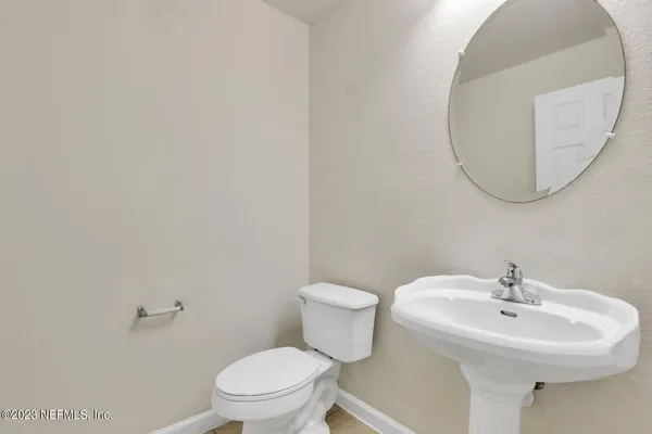 a bathroom with a sink a toilet and a mirror