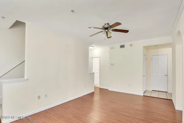 a view of a room with wooden floor and ceiling fan