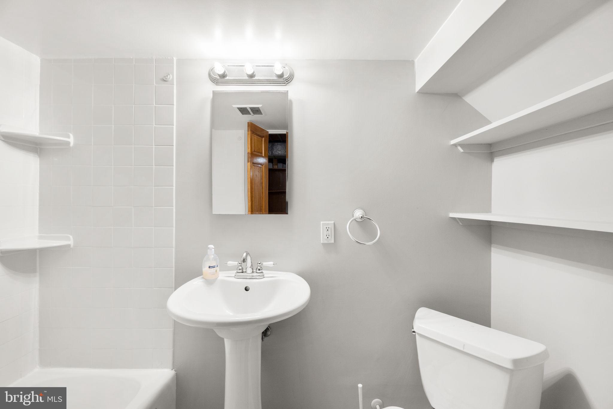 134 Marburth Avenue Baltimore, MD 21286 - Photo 20 of 27 a bathroom with a sink a toilet and shower curtain