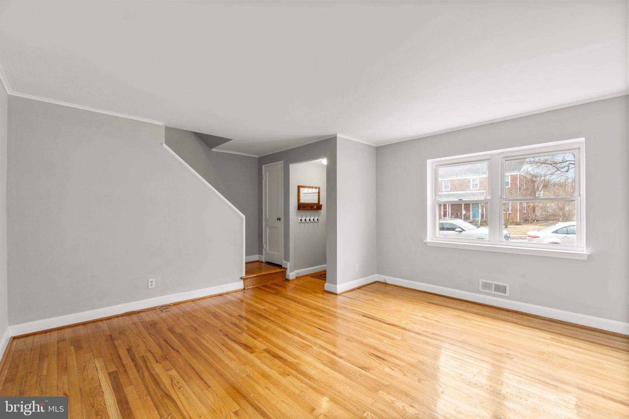 134 Marburth Avenue Baltimore, MD 21286 - Photo 3 of 27 a view of an empty room with wooden floor and a window