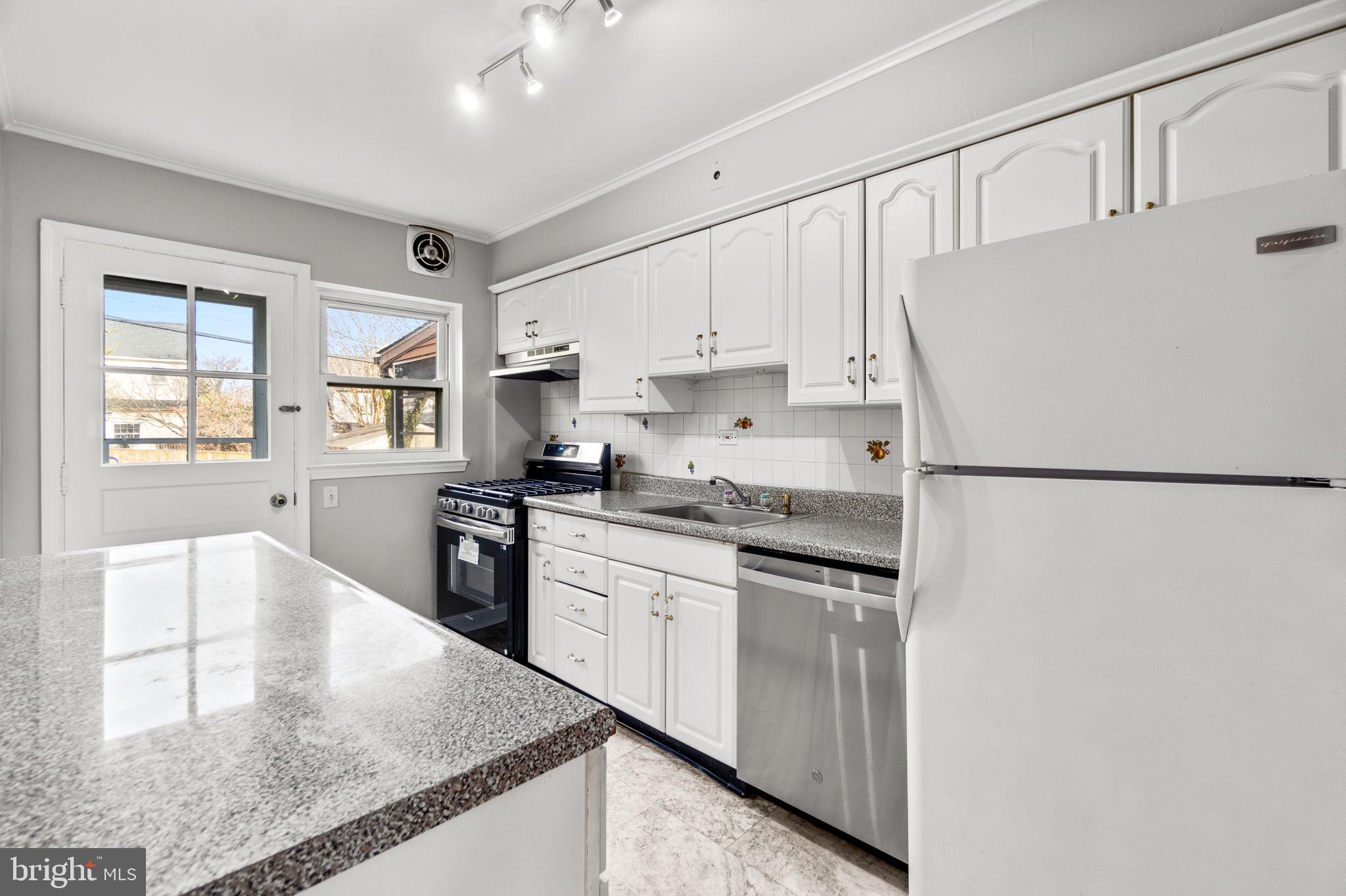 134 Marburth Avenue Baltimore, MD 21286 - Photo 9 of 27 a kitchen with granite countertop white cabinets and white appliances