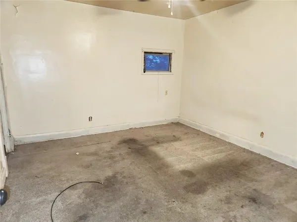 an empty room with a ceiling fan and a fan