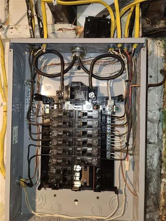 a room with water heater and wooden cabinets