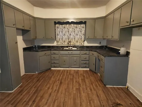 a kitchen with granite countertop a sink cabinets stainless steel appliances and a counter space