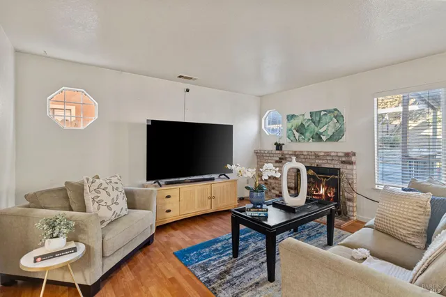 a living room with furniture a flat screen tv and a fireplace