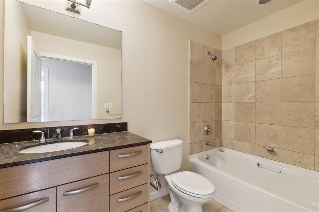 1200 Main Street, Unit 2302 Dallas, TX 75202 - Photo 11 of 22 a bathroom with a granite countertop sink a toilet a mirror and shower