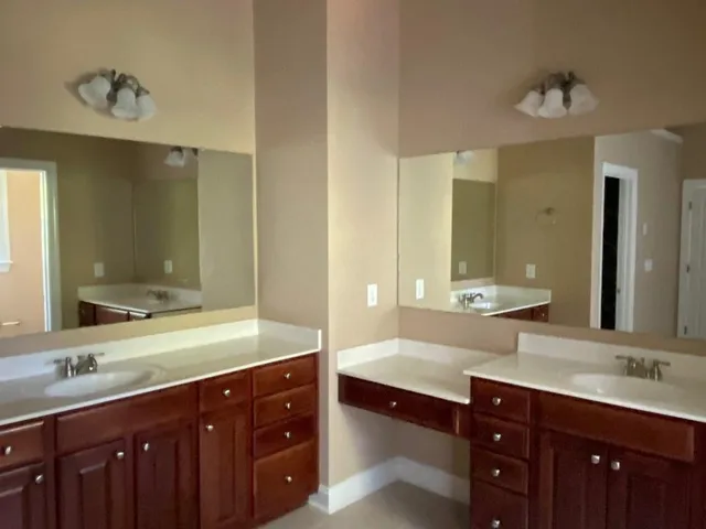 a bathroom with a double vanity sink and a mirror