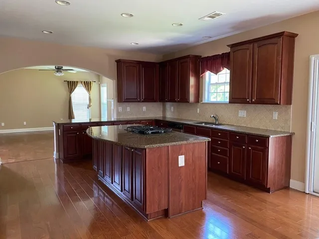 a kitchen with granite countertop a stove a sink and a microwave