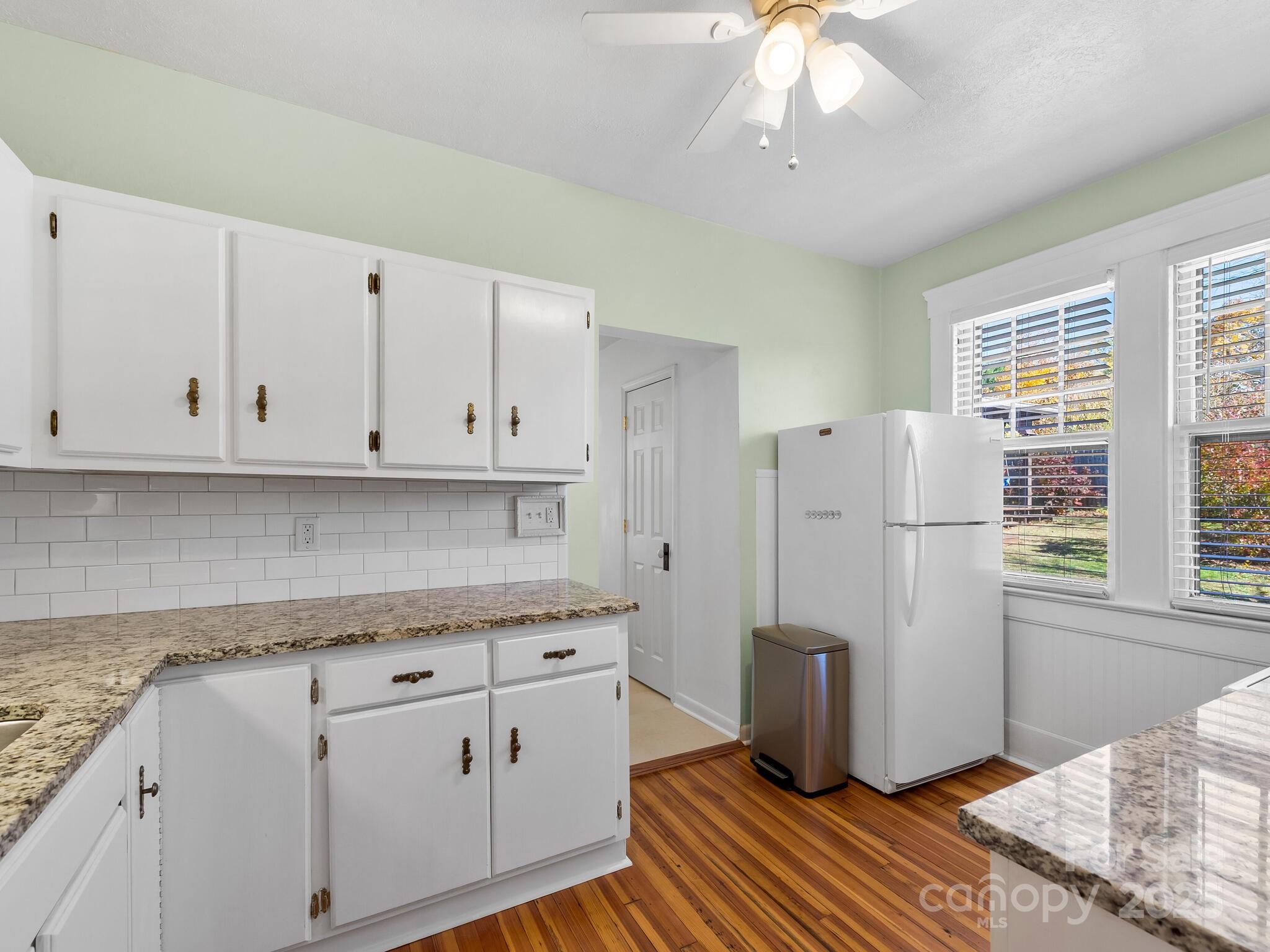 127 Pennsylvania Avenue Asheville, NC 28806 - Photo 18 of 48 a kitchen with granite countertop white cabinets and white appliances