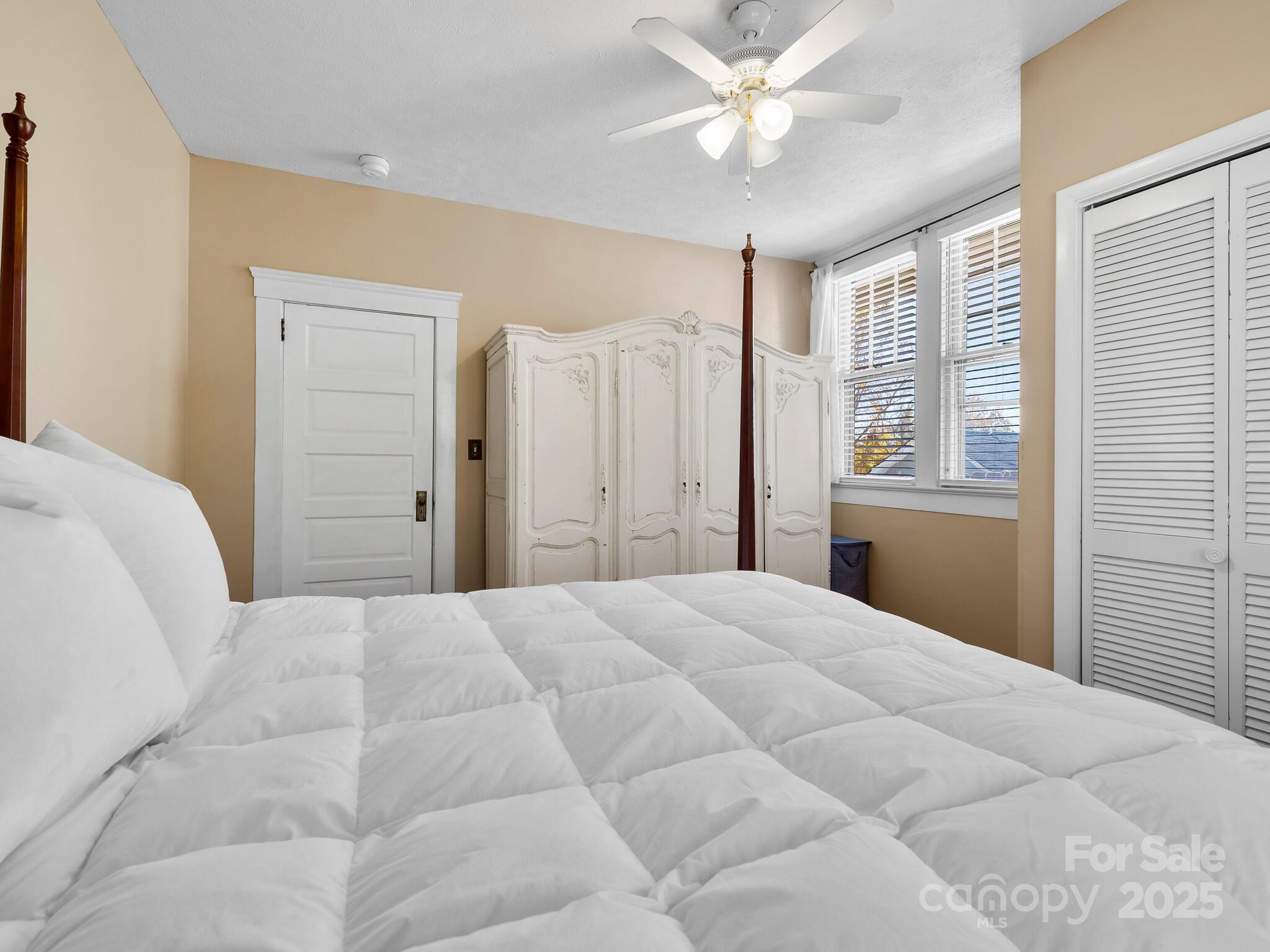 127 Pennsylvania Avenue Asheville, NC 28806 - Photo 27 of 48 a bedroom with a large bed and a chandelier