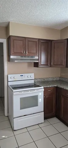 a kitchen with granite countertop a sink cabinets and stainless steel appliances