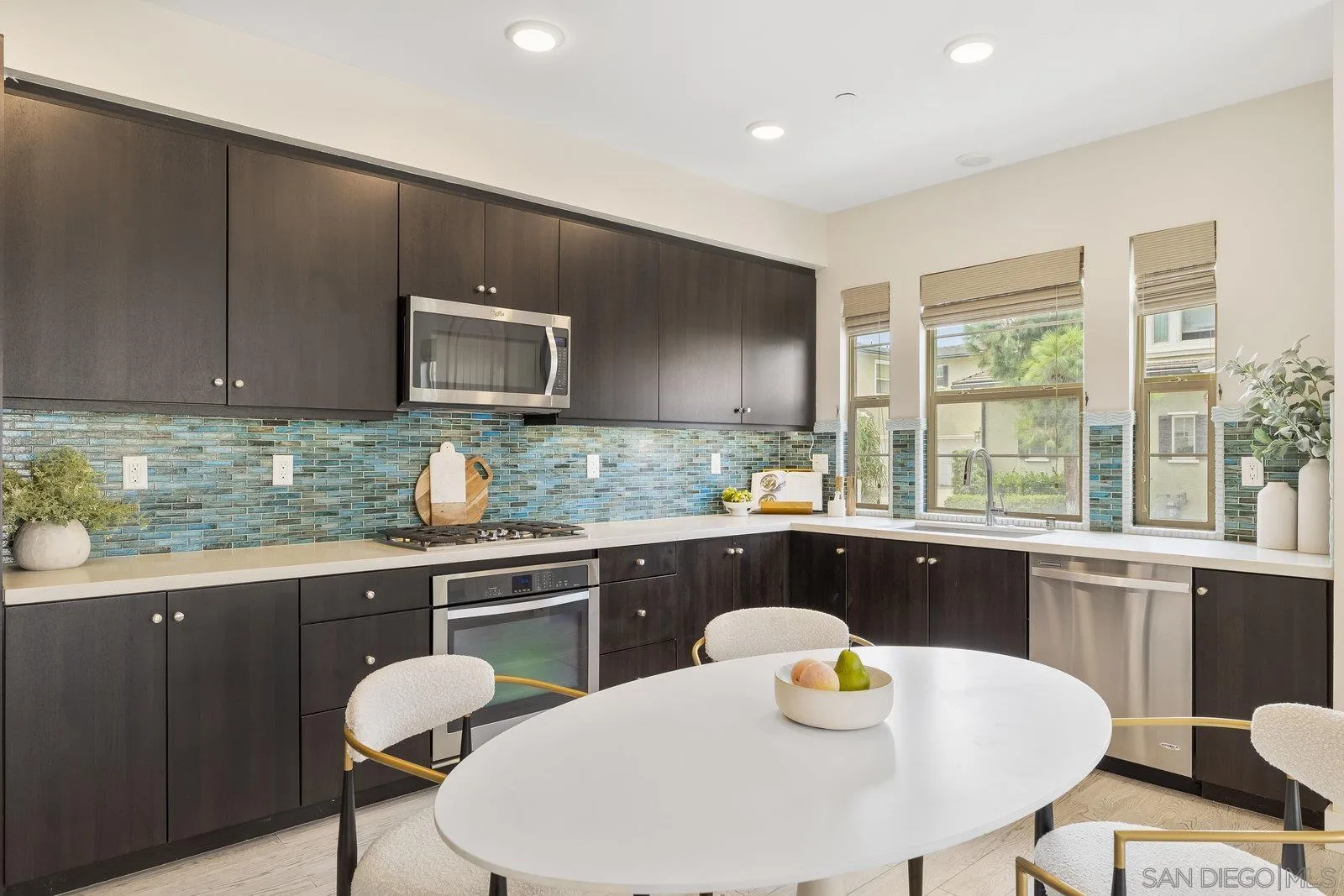 1676 Shorebreak Way Encinitas, CA 92024 - Photo 22 of 61 a kitchen with a sink a stove a table and chairs