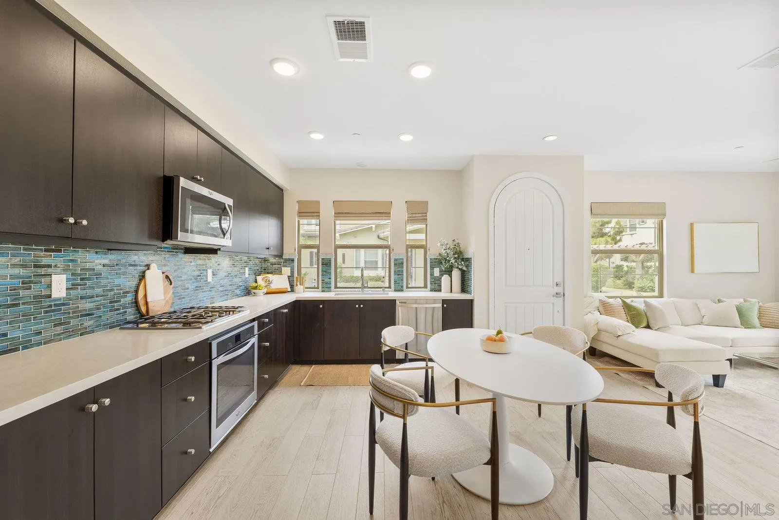 1676 Shorebreak Way Encinitas, CA 92024 - Photo 24 of 61 a large kitchen with stainless steel appliances granite countertop a stove a sink dishwasher a dining table and chairs