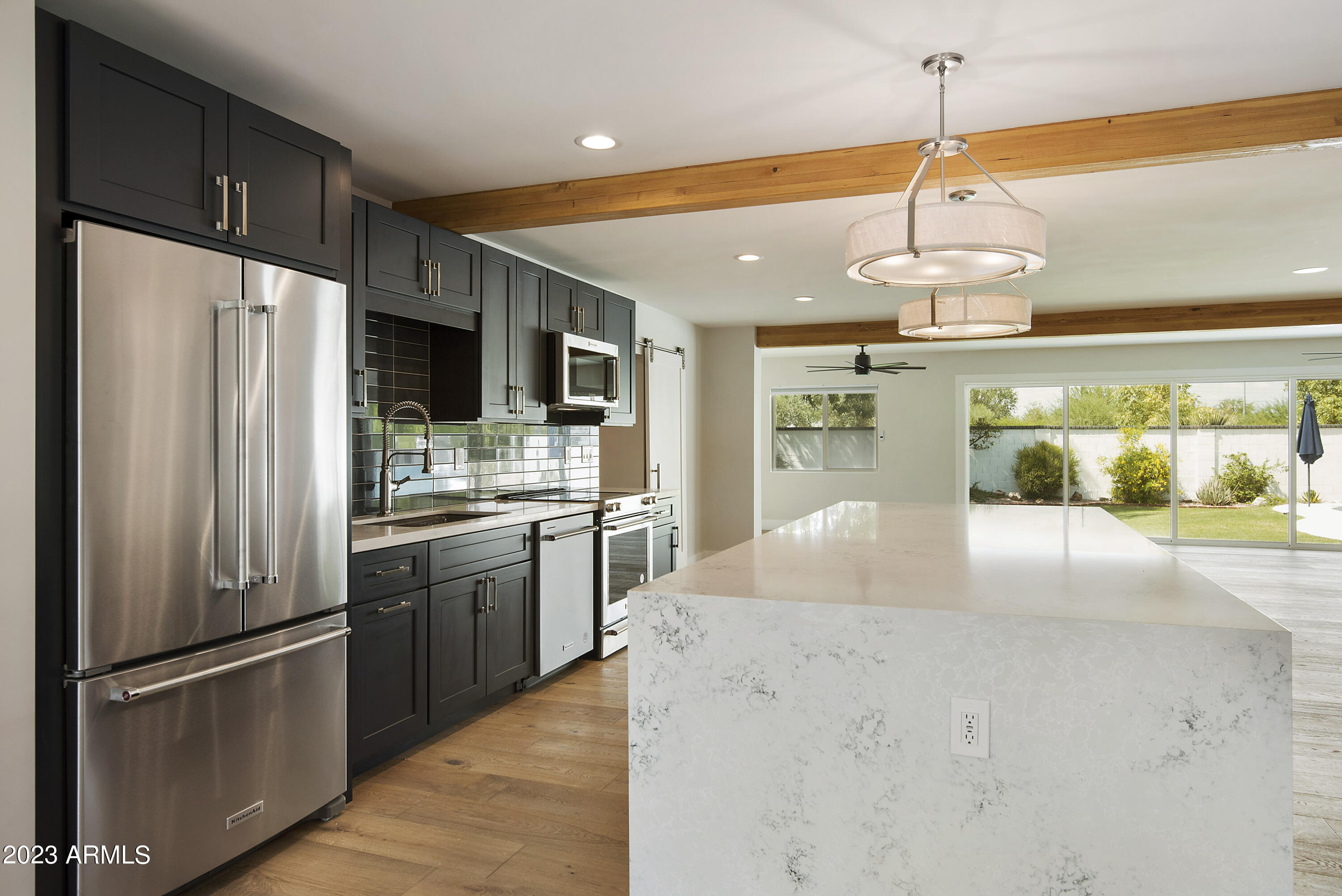 3318 East Onyx Avenue Phoenix, AZ 85028 - Photo 14 of 55 a kitchen with stainless steel appliances granite countertop a refrigerator a oven a sink with island and chairs