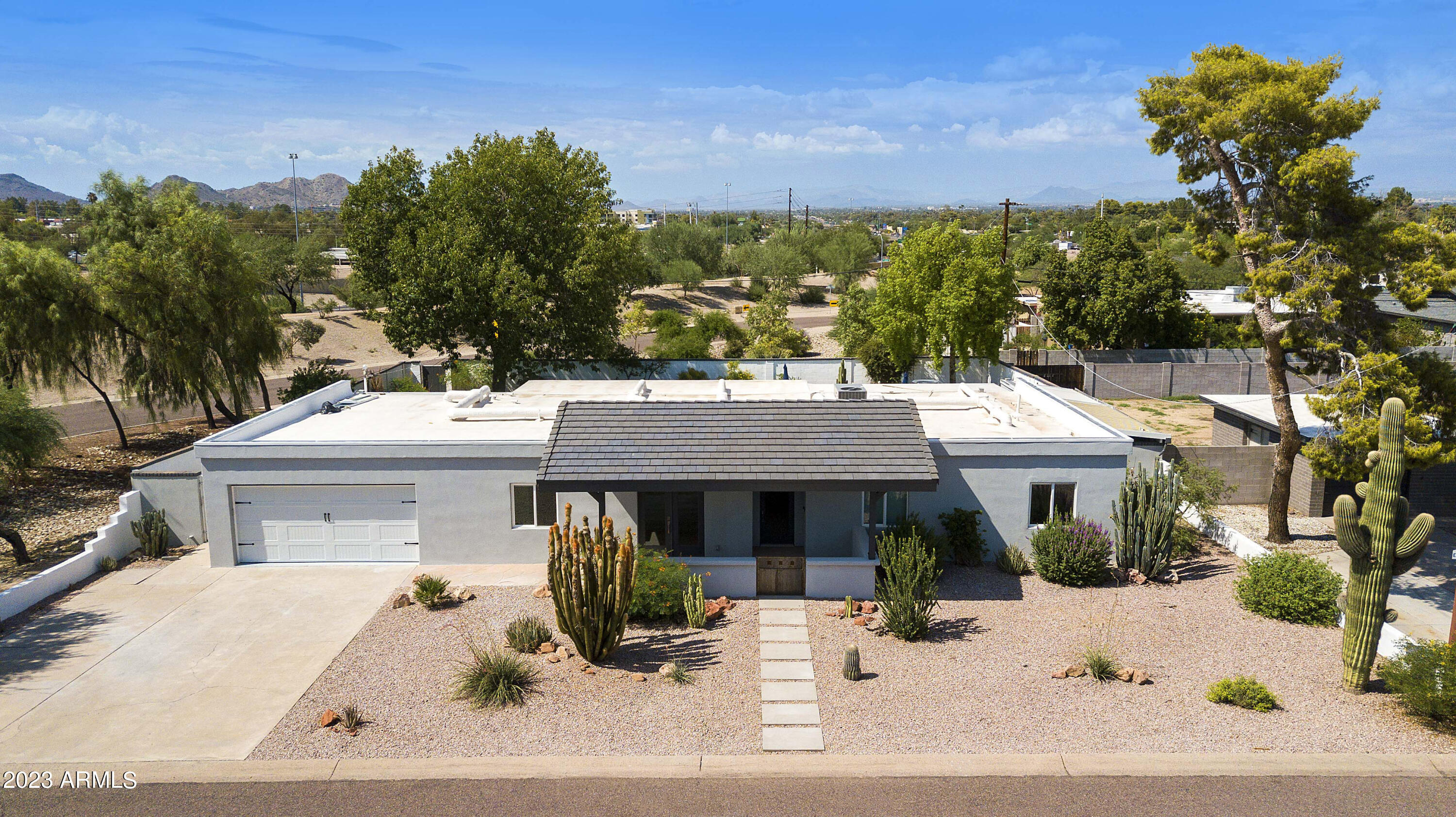 3318 East Onyx Avenue Phoenix, AZ 85028 - Photo 26 of 55 a view of a white house with a large tree in front of it
