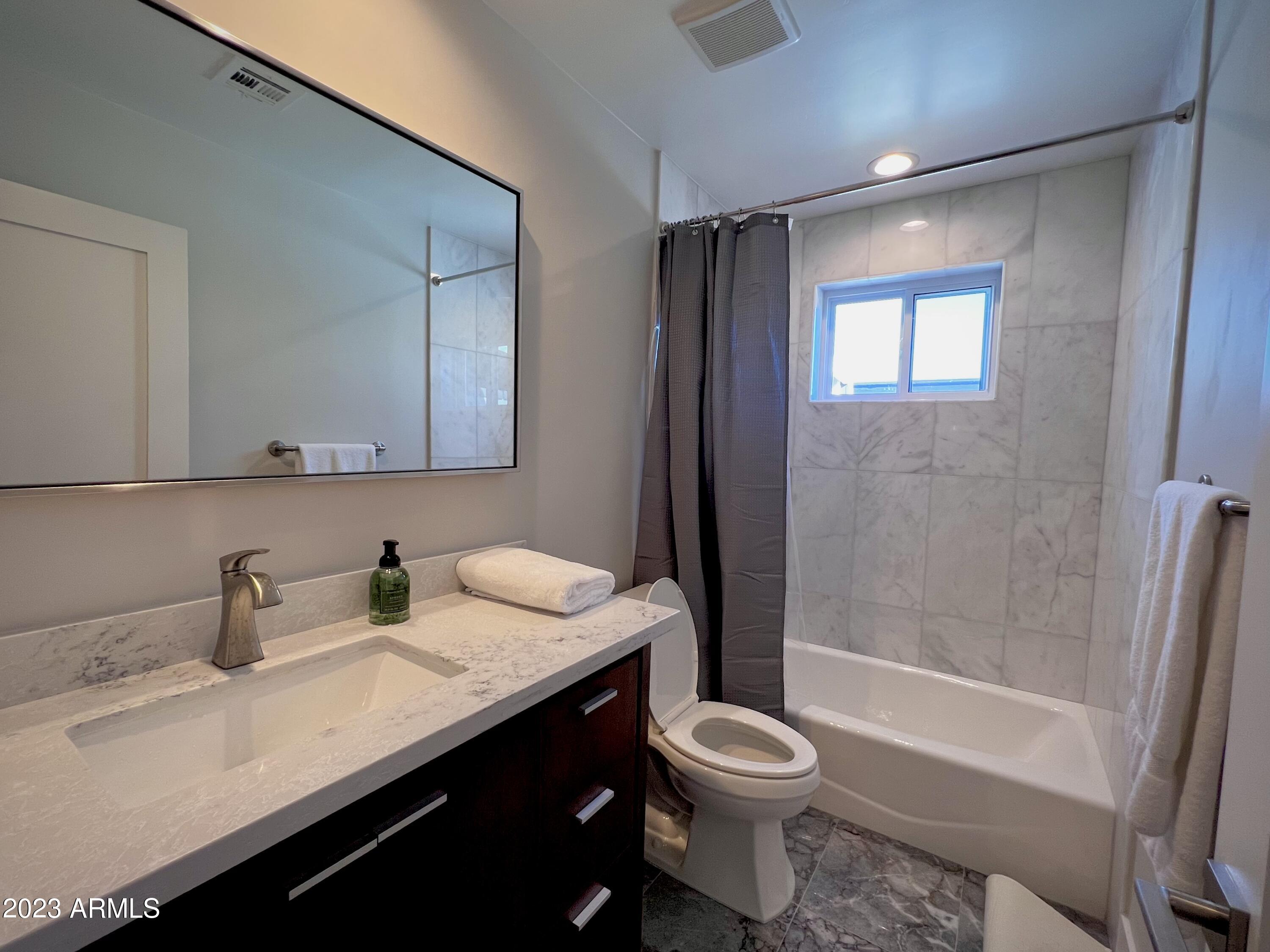 3318 East Onyx Avenue Phoenix, AZ 85028 - Photo 37 of 55 a bathroom with a granite countertop sink toilet and shower