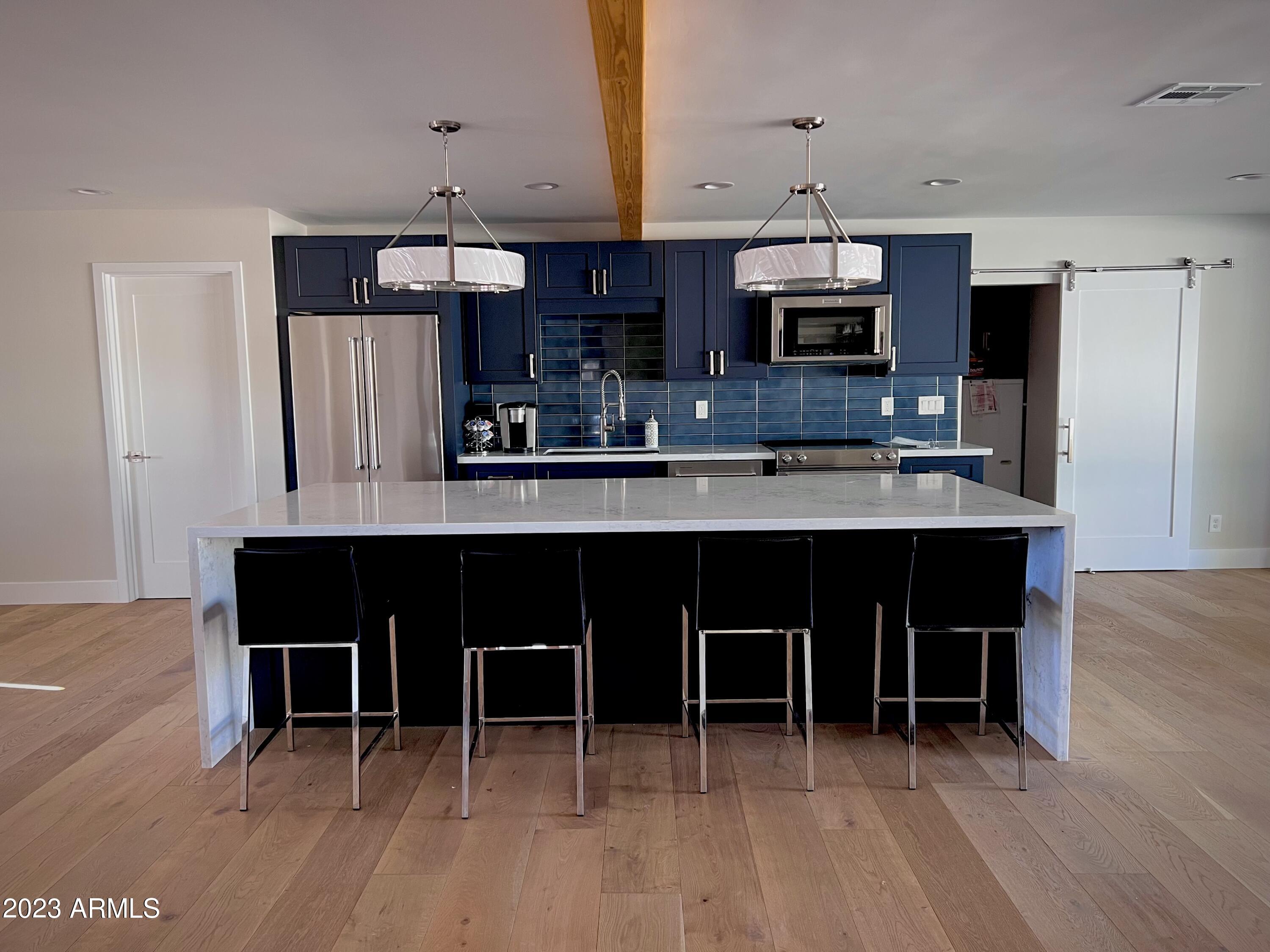 3318 East Onyx Avenue Phoenix, AZ 85028 - Photo 46 of 55 a kitchen with stainless steel appliances a dining table chairs and a refrigerator