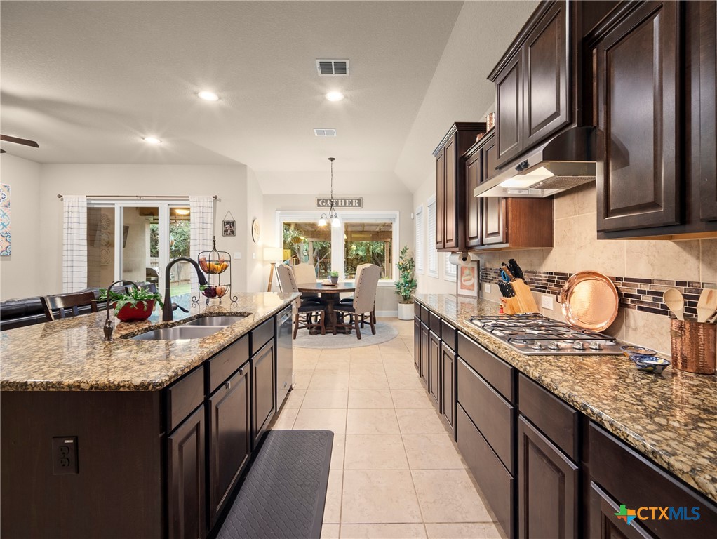 28415 Willis Ranch San Antonio, TX 78260 - Photo 9 of 48 a kitchen with kitchen island granite countertop a sink stove and cabinets