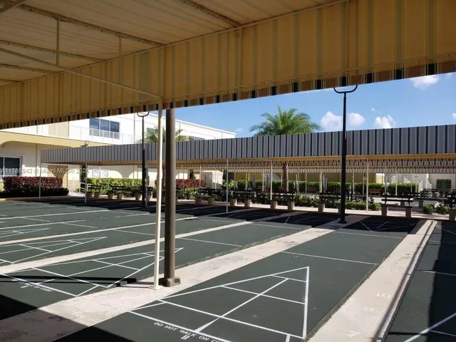 a view of a tennis court with lots of trees in the background