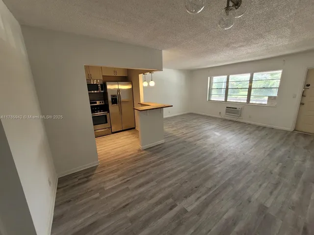 an empty room with wooden floor and entrance