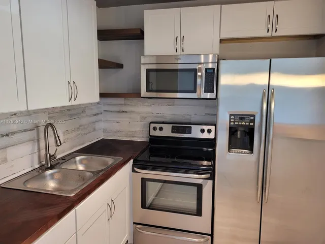 a kitchen with a sink stainless steel appliances and cabinets