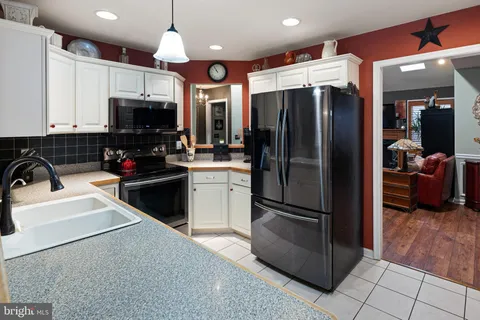 a kitchen with granite countertop a refrigerator and a sink