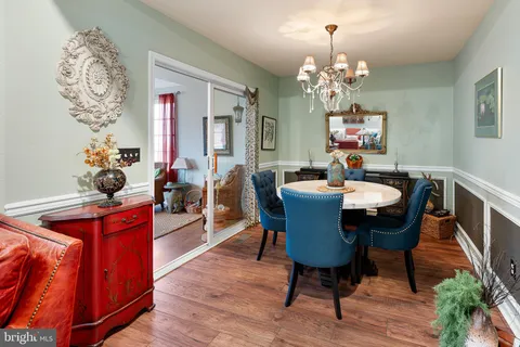 a dining room with furniture a chandelier and wooden floor