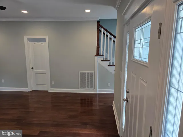 a view of a hallway with wooden floor and stairs
