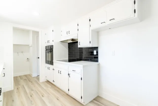 a view of a kitchen with white cabinets