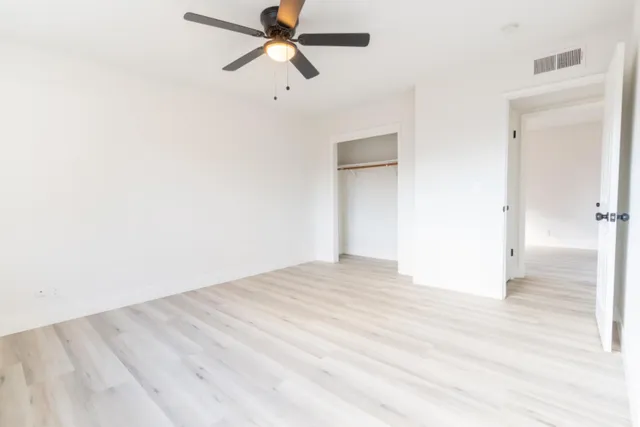 a view of empty room with wooden floor