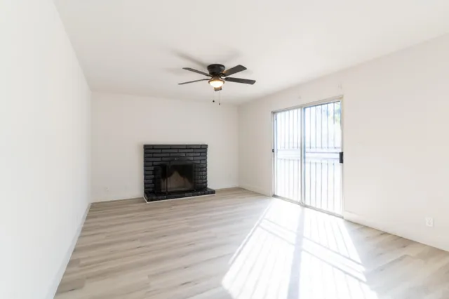 a view of an empty room with a fireplace and a window
