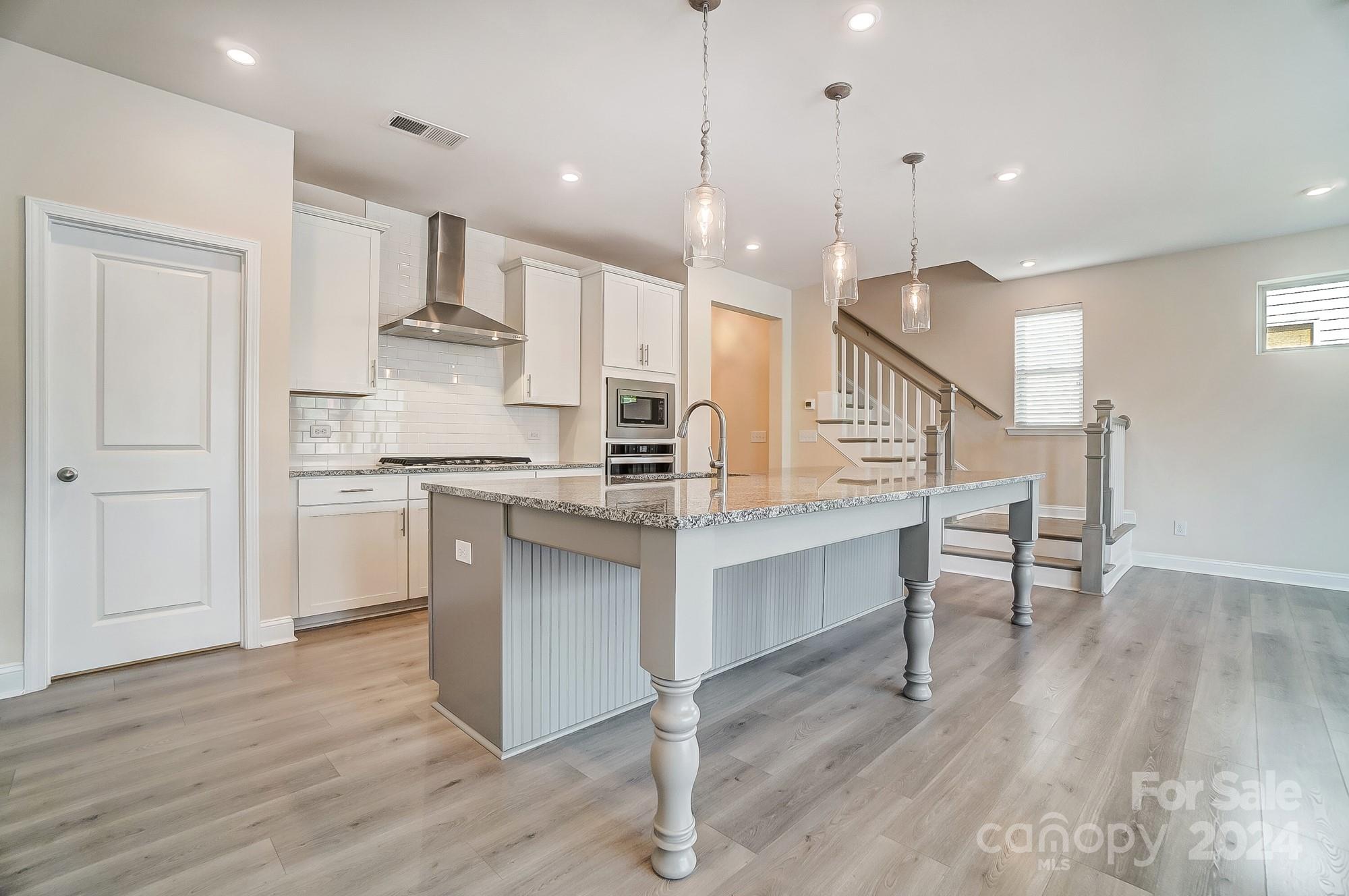 2059 Suttonview Road Fort Mill, SC 29708 - Photo 15 of 44 a kitchen with kitchen island a sink a stove a dining table and chairs