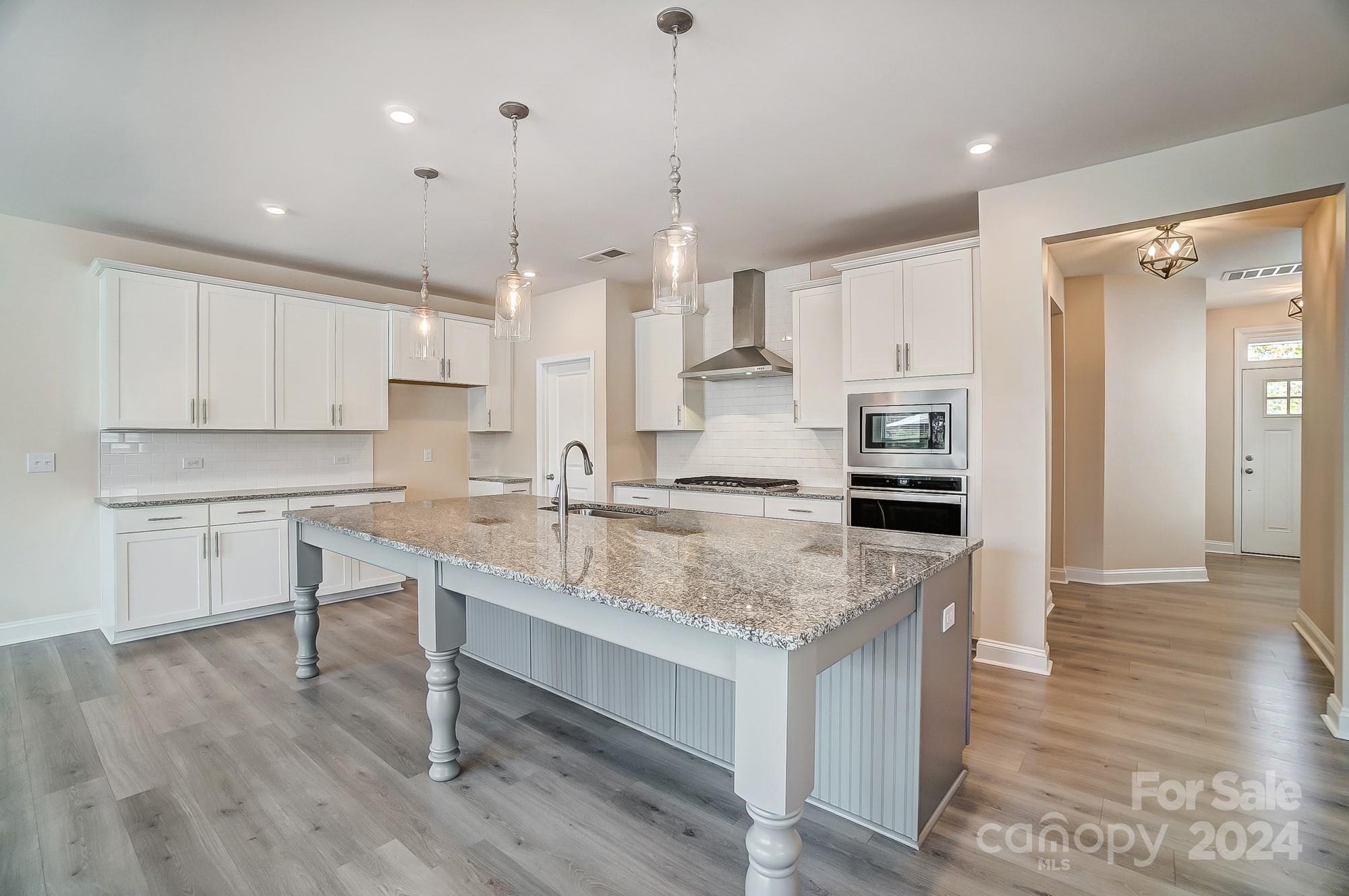2059 Suttonview Road Fort Mill, SC 29708 - Photo 16 of 44 a kitchen with kitchen island a sink stove and white cabinets