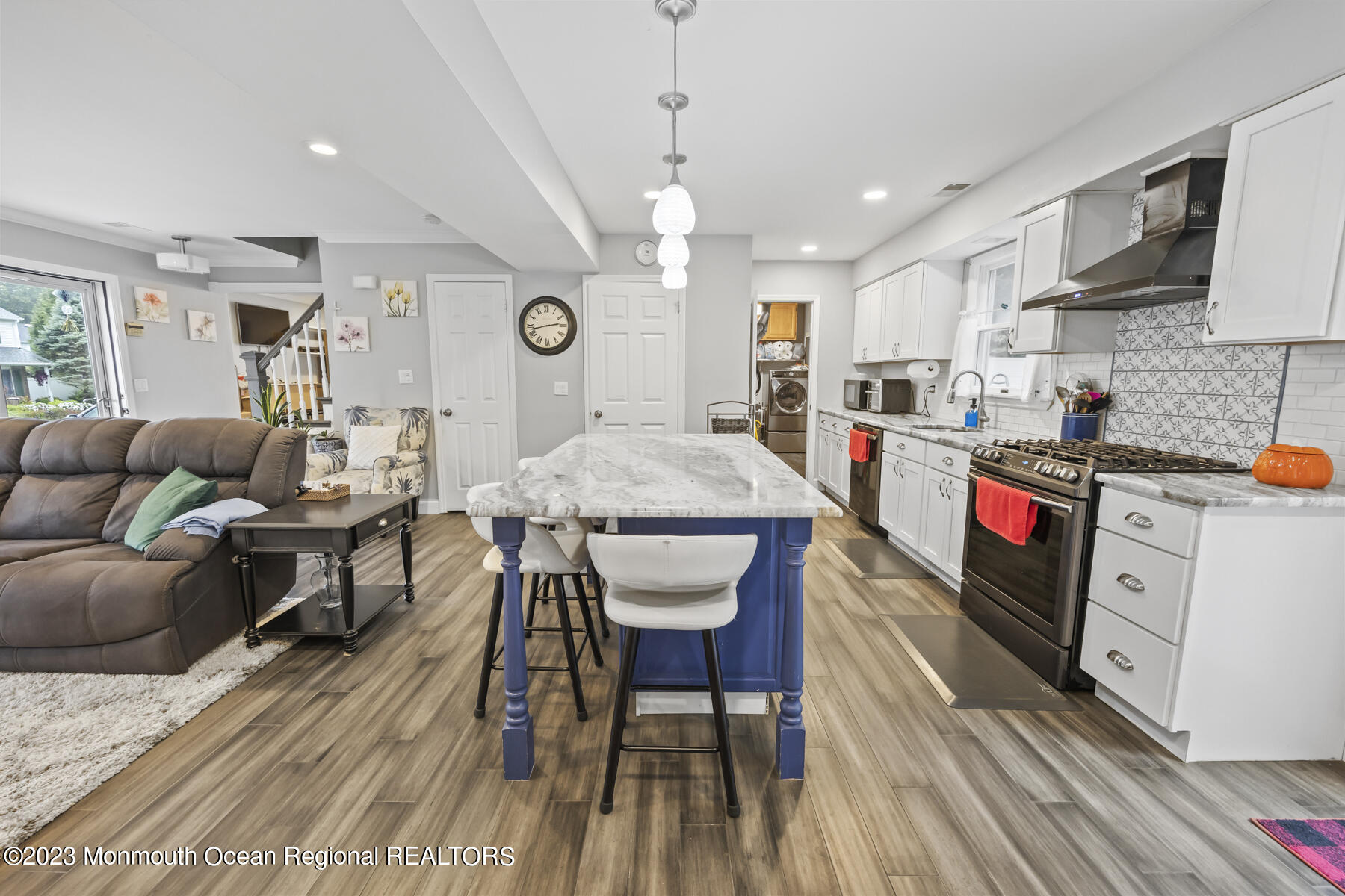 12 Constitution Drive Howell, NJ 07731 - Photo 11 of 39 a large kitchen with stainless steel appliances granite countertop a stove a refrigerator a kitchen island a dining table and chairs with wooden floor