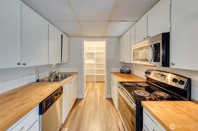 a kitchen that has a sink a table and chairs in it