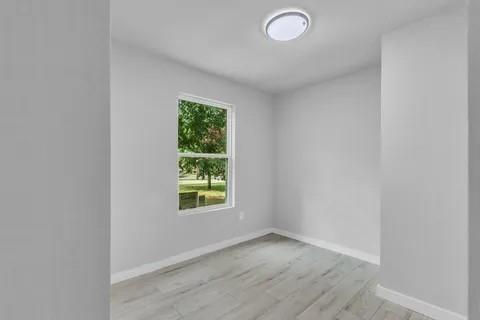 110 North Hillside Street Red Oak, TX 75154 - Photo 19 of 25 Unfurnished room featuring baseboards and light wood-style floors