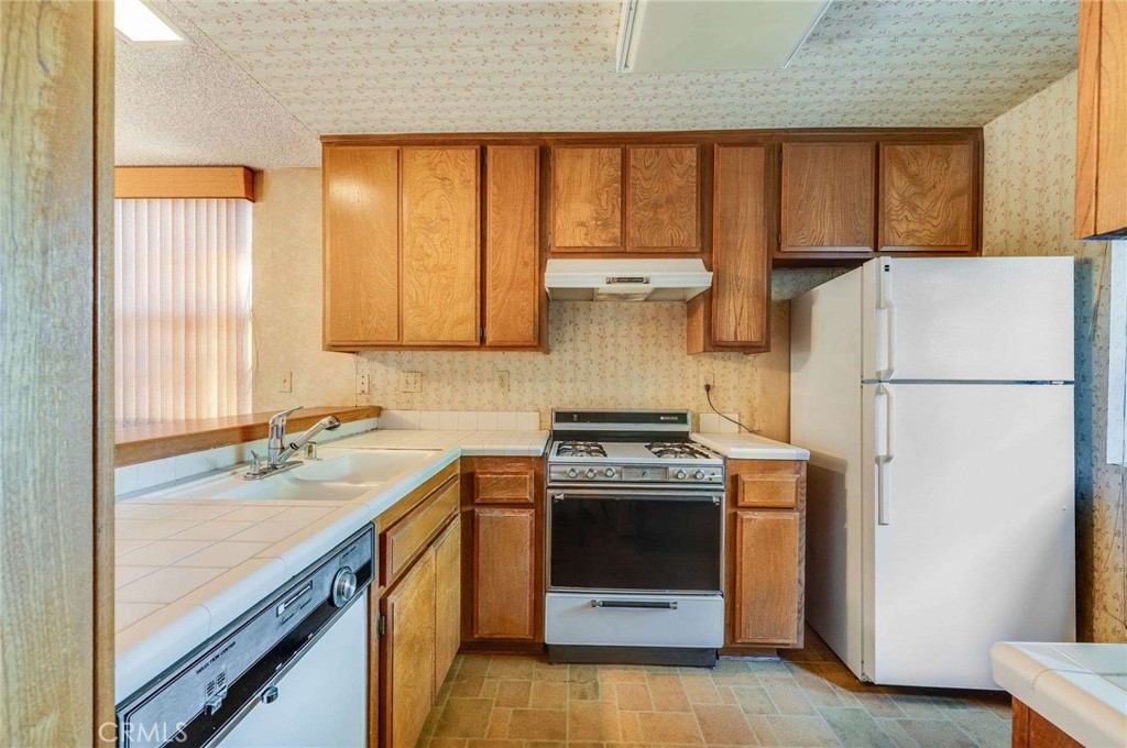 4140 Workman Mill Road, Unit 170 Whittier, CA 90601 - Photo 9 of 32 a kitchen with a stove a refrigerator and a sink
