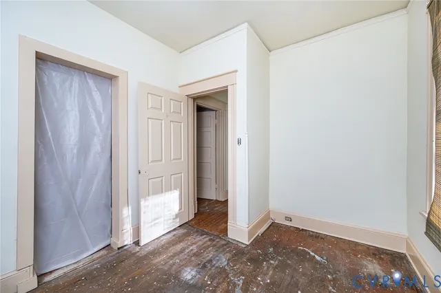 a view of a room with wooden floor and entryway