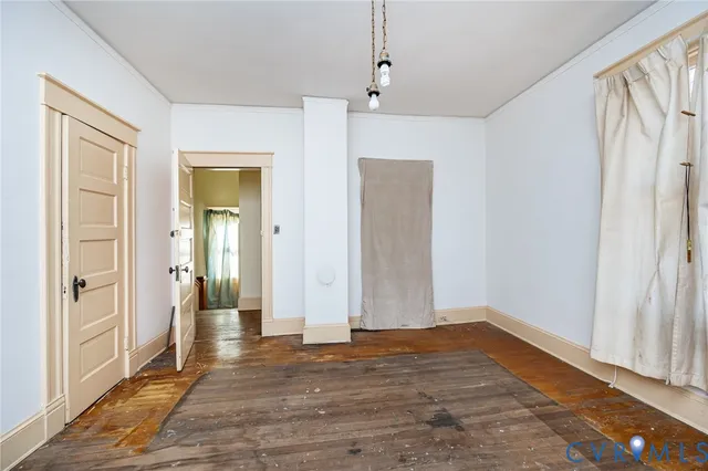 a view of a hallway with wooden floor and a livingroom