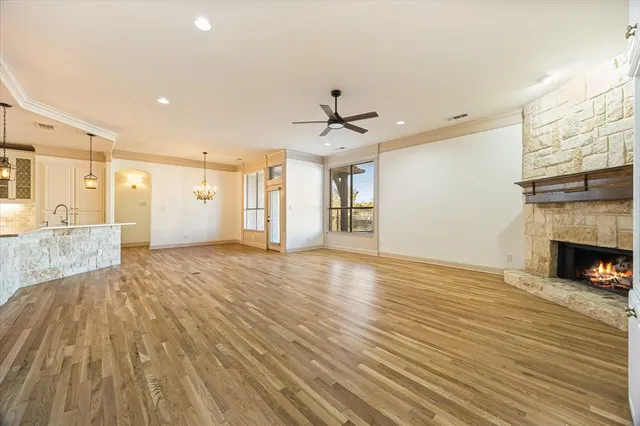 a view of a livingroom with a fireplace a chandelier and wooden floor